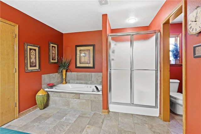 bathroom with a textured ceiling, toilet, and independent shower and bath