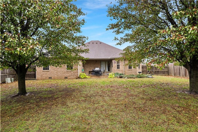 rear view of property featuring a lawn