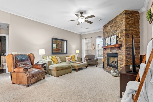 carpeted living room with ceiling fan, a stone fireplace, and ornamental molding