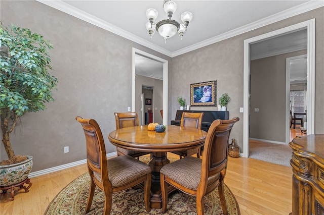 dining space featuring light hardwood / wood-style flooring, ornamental molding, and a notable chandelier