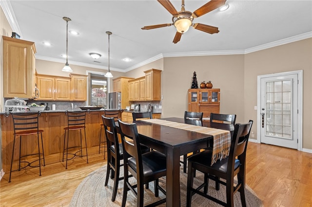 dining room with crown molding, ceiling fan, and light hardwood / wood-style floors