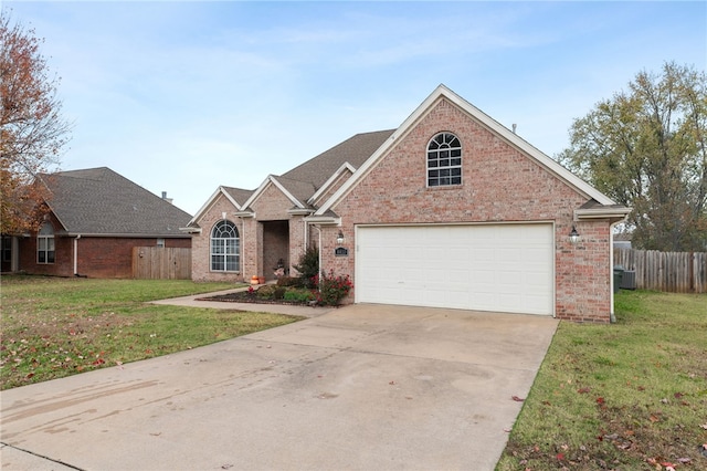 view of property featuring a front yard, a garage, and central air condition unit