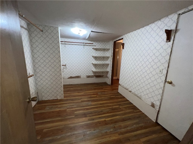 basement featuring dark wood-type flooring and a textured ceiling