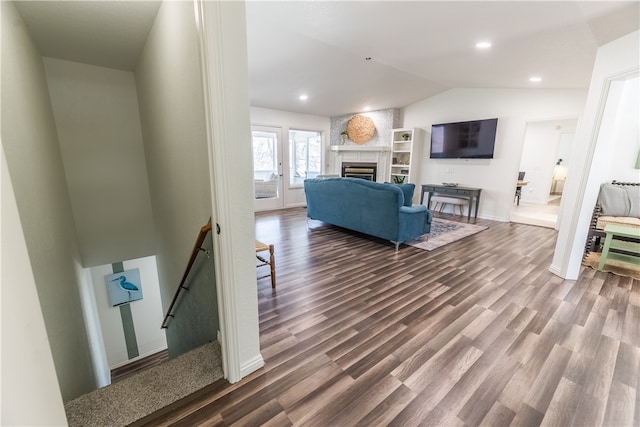 living room with a fireplace, wood-type flooring, and vaulted ceiling