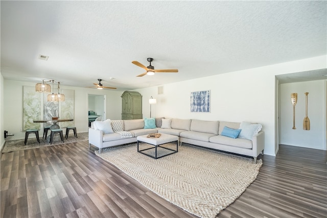 living room featuring a textured ceiling, ceiling fan, and dark hardwood / wood-style floors