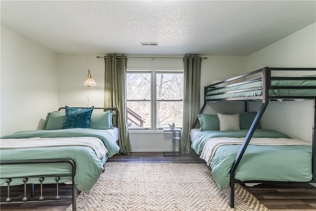 bedroom with a textured ceiling and hardwood / wood-style flooring