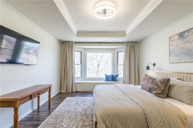 bedroom featuring a raised ceiling, a textured ceiling, dark hardwood / wood-style floors, and ornamental molding