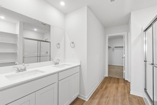 bathroom featuring hardwood / wood-style floors, vanity, and an enclosed shower