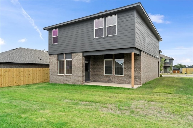 back of house featuring a lawn and a patio area