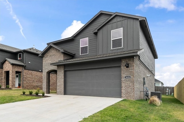 view of front of home featuring central AC, a front yard, and a garage