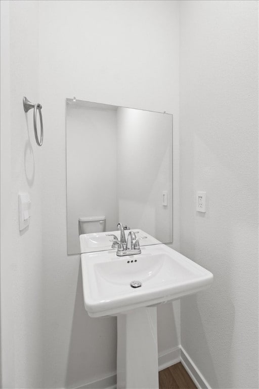 bathroom featuring hardwood / wood-style flooring, sink, and toilet