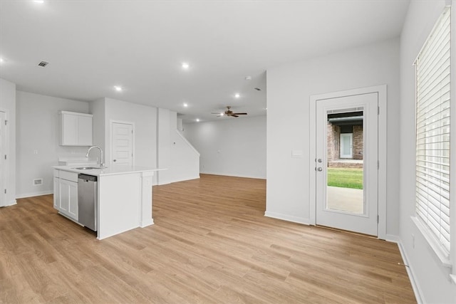 kitchen featuring stainless steel dishwasher, white cabinets, sink, and light hardwood / wood-style flooring