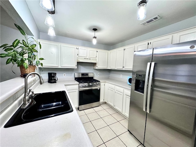 kitchen featuring appliances with stainless steel finishes, sink, light tile patterned floors, pendant lighting, and white cabinets