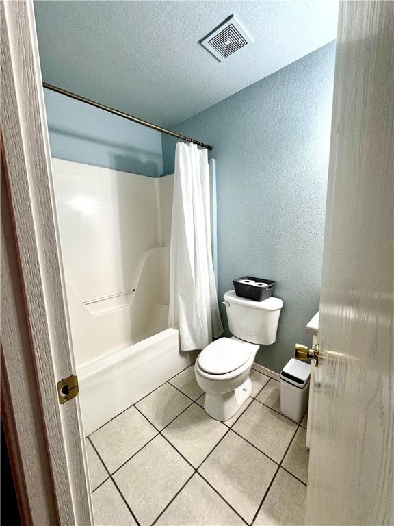 bathroom with toilet, shower / bath combination with curtain, a textured ceiling, and tile patterned floors