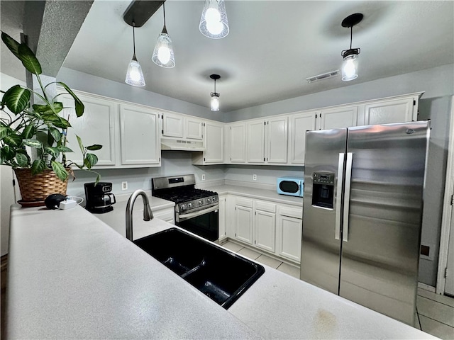 kitchen with decorative light fixtures, white cabinetry, and stainless steel appliances