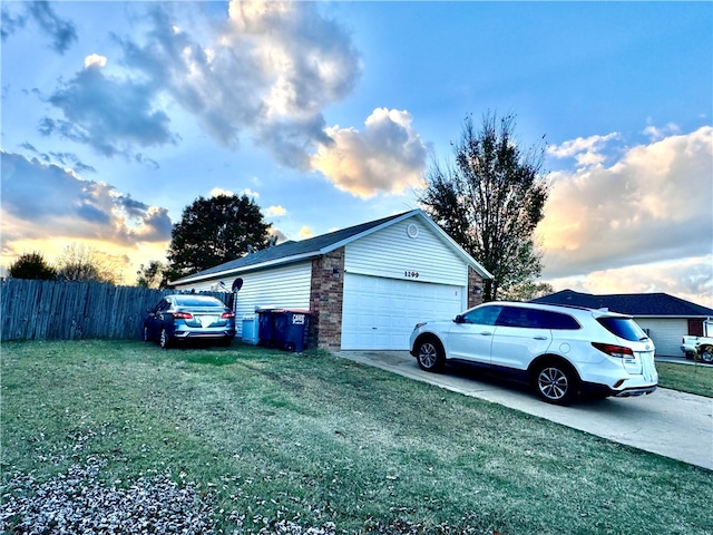 property exterior at dusk featuring a yard and a garage