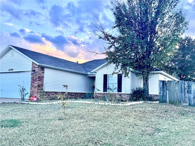 ranch-style house with a garage and a lawn