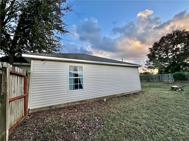 property exterior at dusk featuring a yard