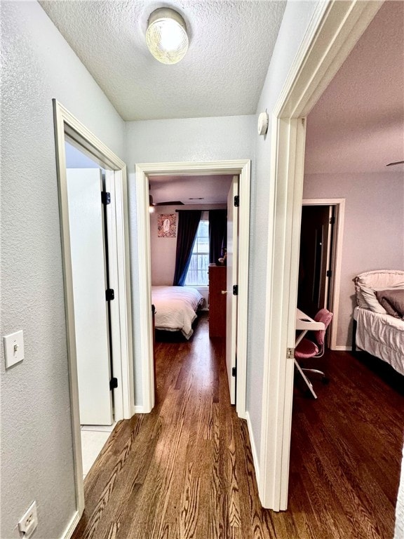 hallway featuring dark hardwood / wood-style floors and a textured ceiling