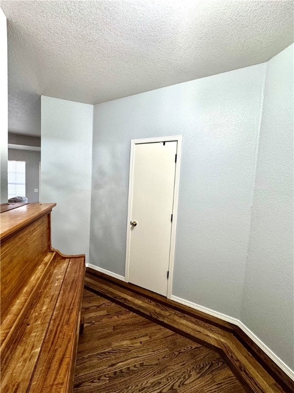 interior space with dark hardwood / wood-style flooring and a textured ceiling