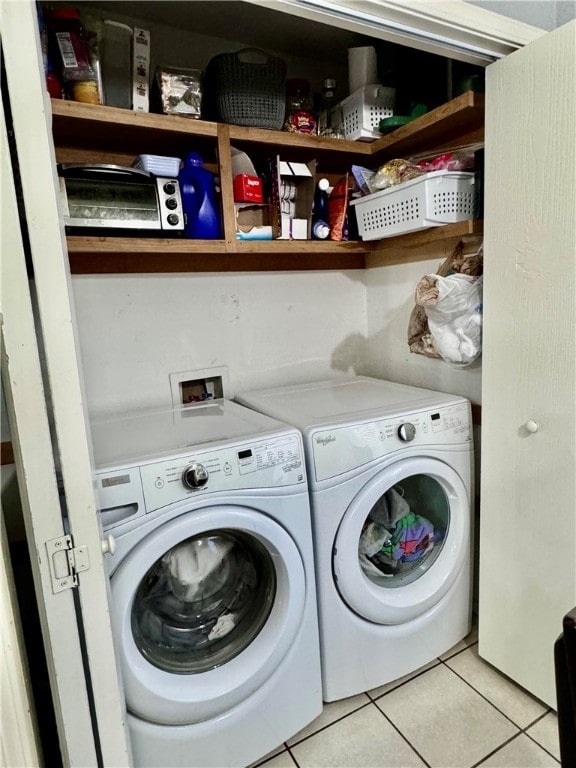 laundry room featuring washer and dryer and light tile patterned floors