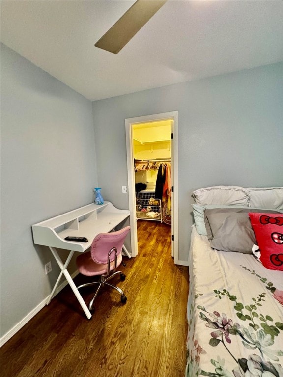 bedroom with hardwood / wood-style floors, a spacious closet, and a closet