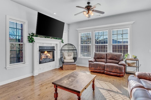 living room featuring ceiling fan, plenty of natural light, and light wood-type flooring