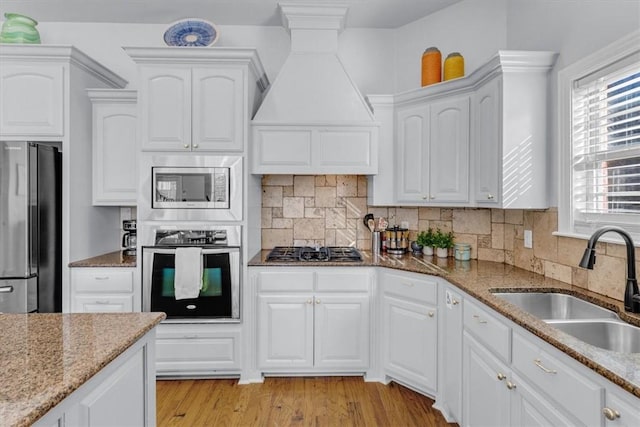 kitchen featuring stone countertops, sink, white cabinets, and appliances with stainless steel finishes