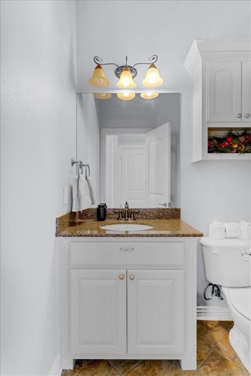 bathroom with tile patterned flooring, vanity, and toilet