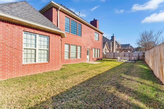 rear view of property featuring a lawn and a patio