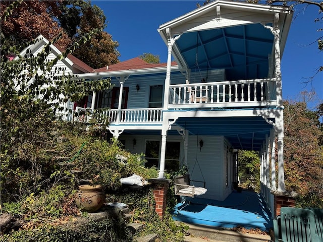 rear view of house featuring covered porch