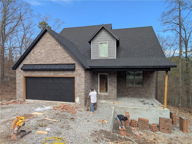 view of front of house featuring brick siding, roof with shingles, and an attached garage