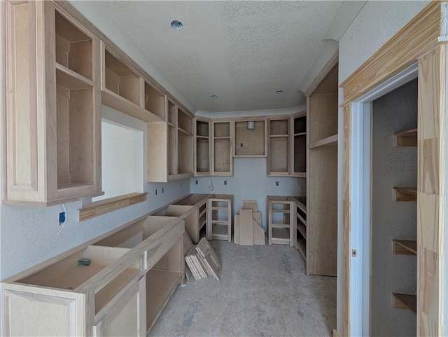 kitchen featuring open shelves, a textured ceiling, and a textured wall