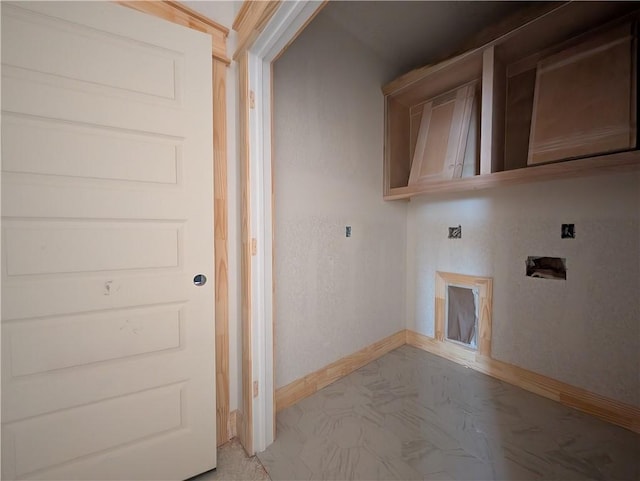 clothes washing area featuring baseboards