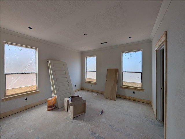 interior space with visible vents, crown molding, a textured ceiling, and baseboards