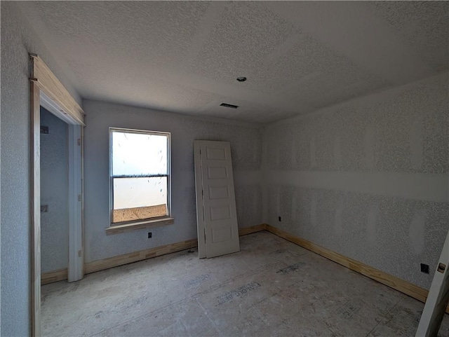 unfurnished bedroom featuring baseboards and a textured ceiling