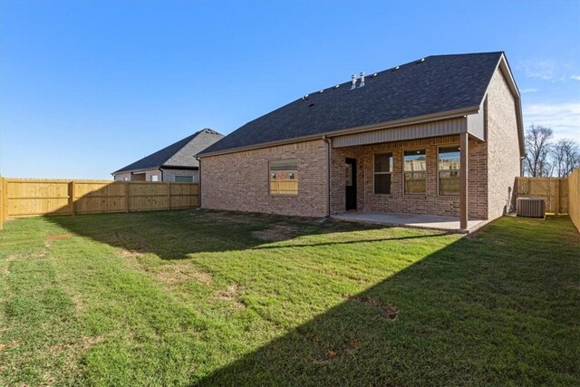 rear view of property with central air condition unit, a yard, and a patio