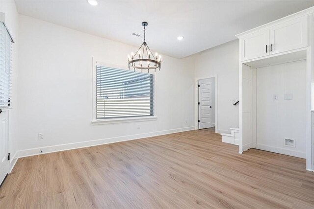 unfurnished dining area with light hardwood / wood-style floors and a chandelier