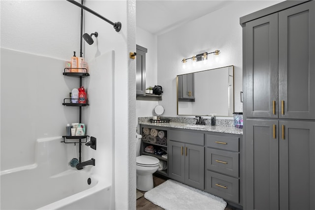 full bathroom with vanity, hardwood / wood-style flooring, toilet, and shower / bathtub combination