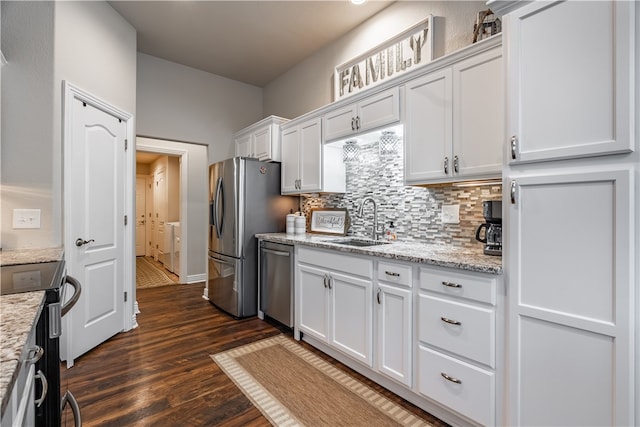 kitchen with appliances with stainless steel finishes, dark hardwood / wood-style flooring, light stone counters, sink, and white cabinetry