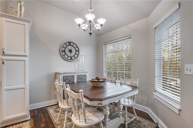 dining room featuring dark hardwood / wood-style flooring, a chandelier, and vaulted ceiling