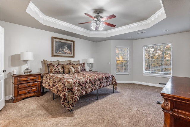 carpeted bedroom with a tray ceiling, ceiling fan, and crown molding