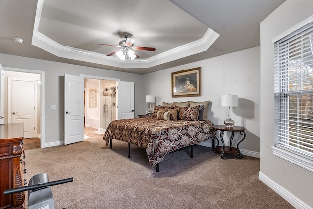 bedroom with carpet flooring, ceiling fan, a tray ceiling, and ensuite bathroom