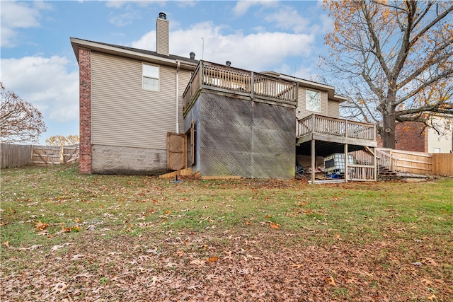 back of property with a lawn and a deck