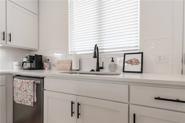 kitchen with dishwasher, decorative backsplash, white cabinets, and sink