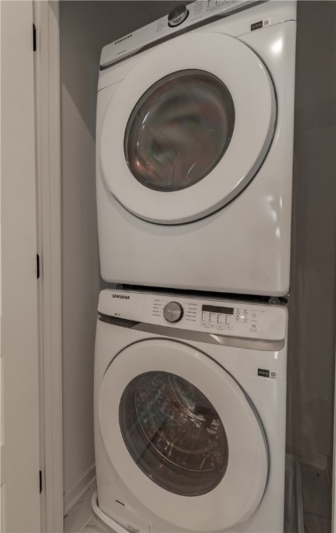 clothes washing area featuring stacked washing maching and dryer