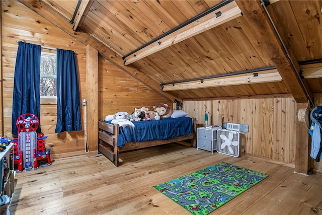 bedroom with lofted ceiling with beams, wood ceiling, wood walls, and light wood-style floors