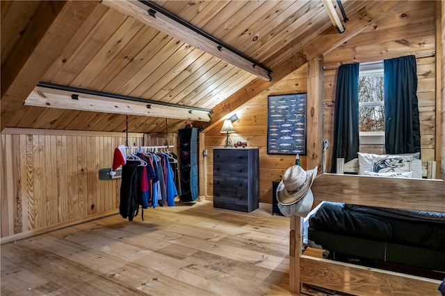 unfurnished bedroom with wood walls, light wood finished floors, wood ceiling, and lofted ceiling with beams