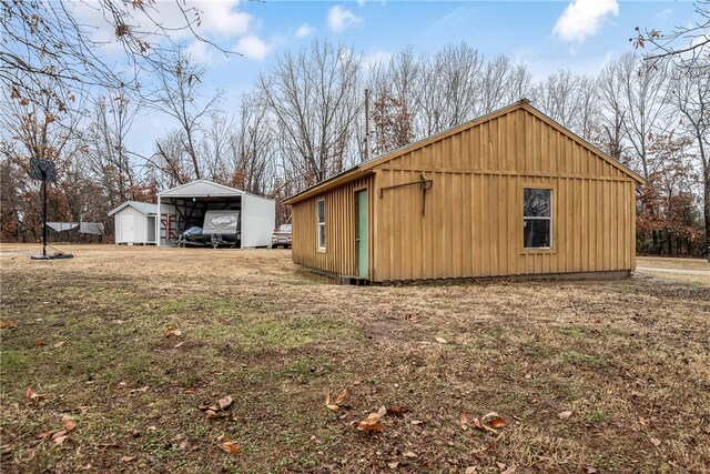 view of property exterior featuring a carport and an outdoor structure