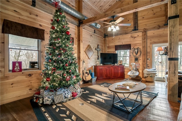 living room featuring wood-type flooring, high vaulted ceiling, plenty of natural light, and wooden walls